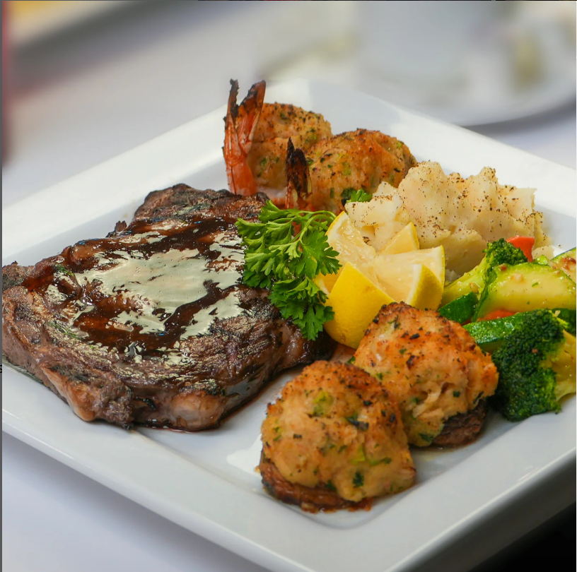Surf and turf dinner plate at City Cafe in Chattanooga featuring grilled steak, shrimp, crab cakes, mashed potatoes, and seasonal vegetables—perfect for those searching “restaurants near me” or planning a hearty breakfast or brunch in downtown Chattanooga.