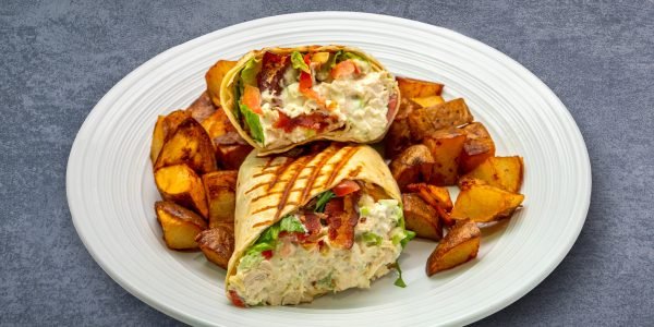Image 3 Grilled chicken salad wrap with bacon, lettuce, tomato, and a side of roasted potatoes, served at a restaurant in downtown Chattanooga.